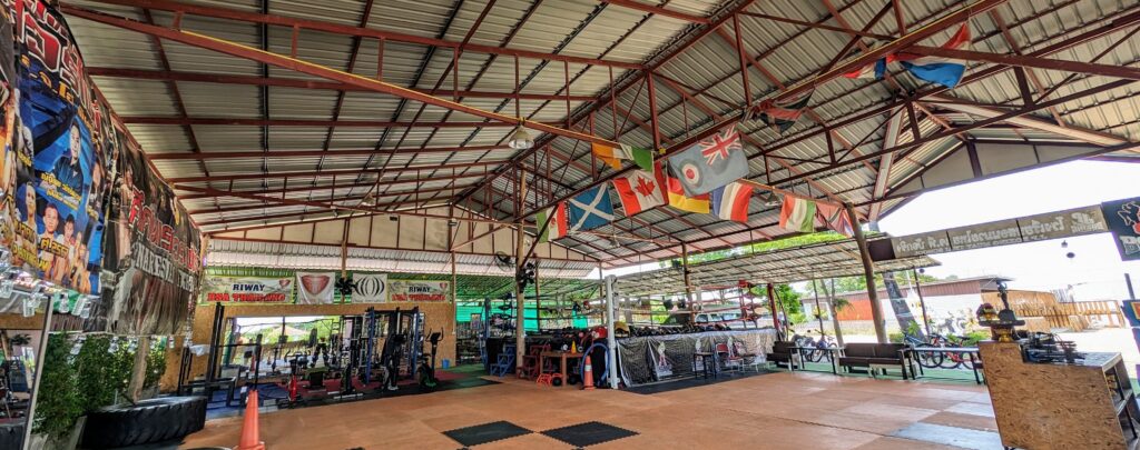 A boxing gym in Thailand with a ring and gym eqipment.